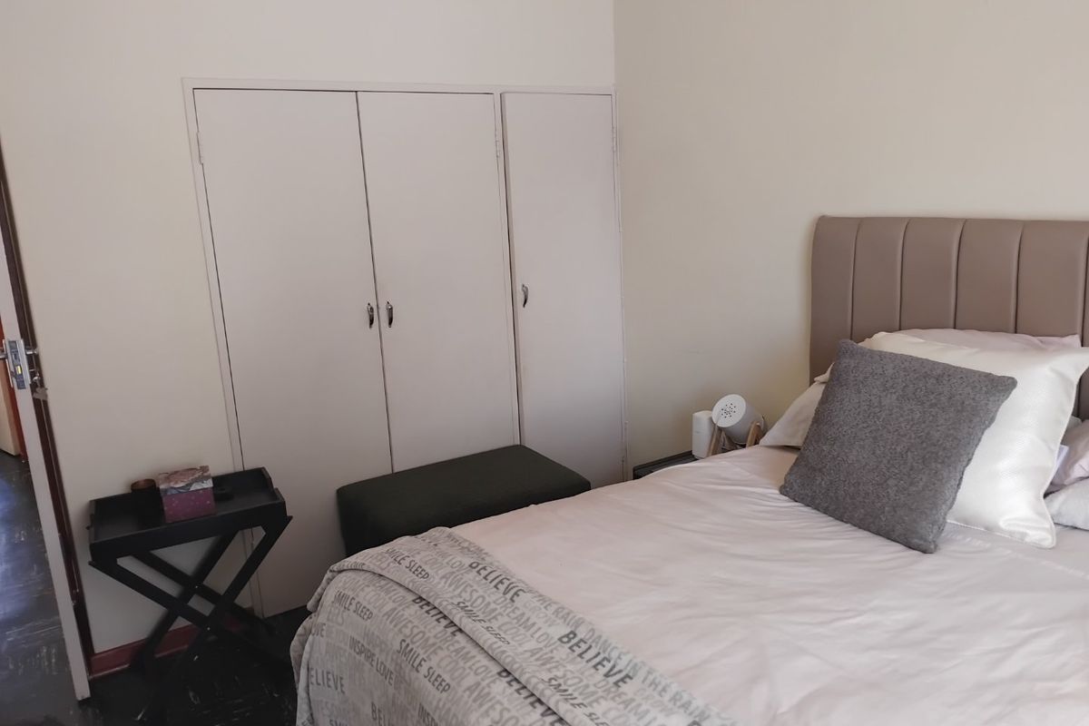 A bedroom featuring built-in cupboards and neutral wall finishes, providing a functional and comfortable sleeping space.
