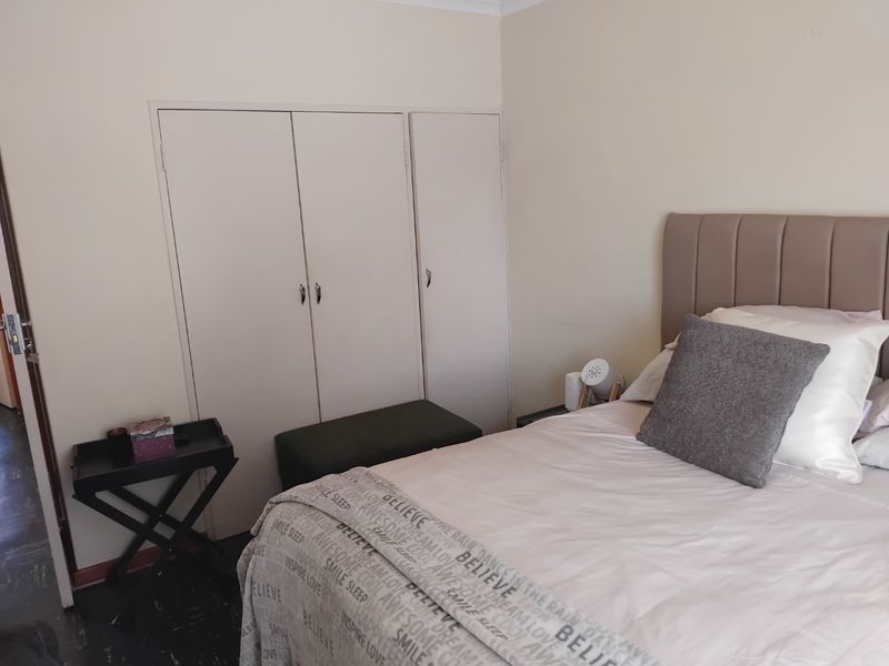 A bedroom featuring built-in cupboards and neutral wall finishes, providing a functional and comfortable sleeping space.