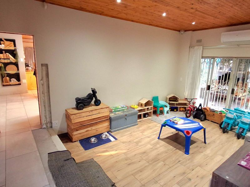 Living area featuring wood-look tile flooring, a timber-clad ceiling with recessed lighting, and a split-system air conditioner, with access to an outdoor area.