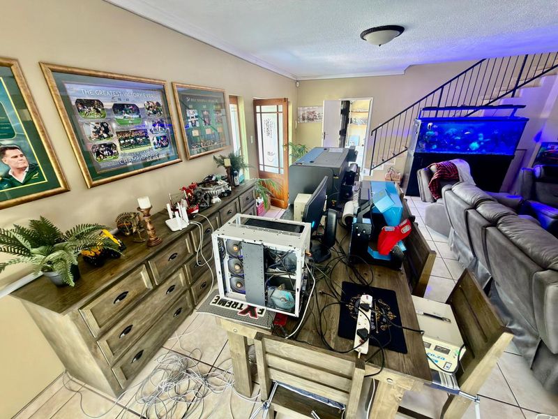A spacious living area featuring tiled flooring, a staircase leading to the upper level, and neutral wall finishes.
