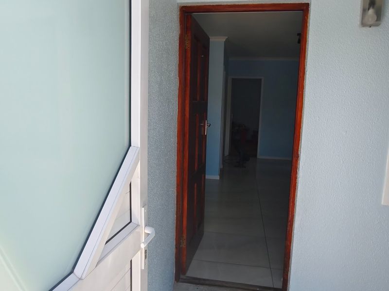Entrance area featuring a timber door and tiled flooring, providing access into the interior of the home.