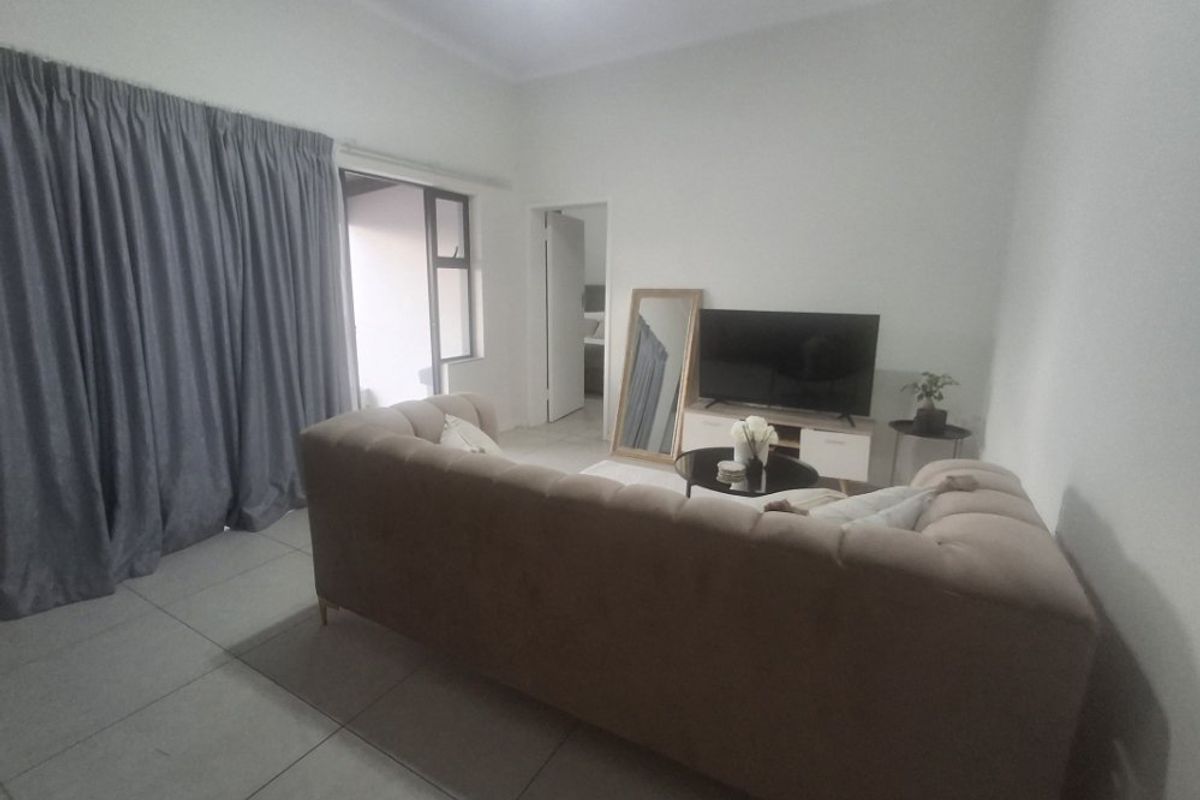 A living room featuring tiled flooring and a sliding glass door providing access to an outdoor area.
