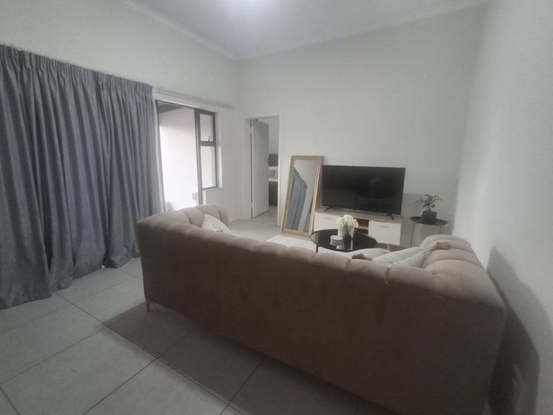 A living room featuring tiled flooring and a sliding glass door providing access to an outdoor area.