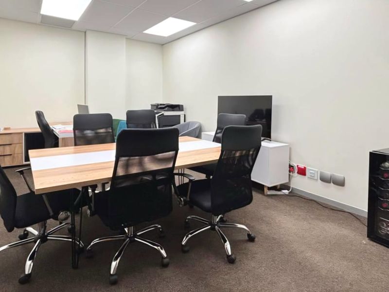 A functional office space featuring carpeted flooring, suspended ceiling with recessed lighting, and integrated electrical and data connectivity.