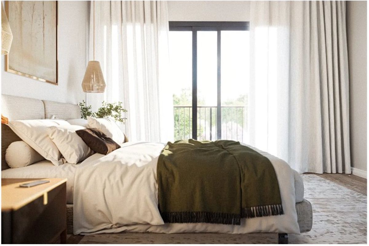 A bright and modern bedroom featuring large sliding glass doors that open onto a private balcony, allowing for ample natural light.
