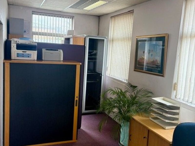 A functional commercial office space featuring suspended ceilings, air conditioning, vertical blinds, and integrated server infrastructure.