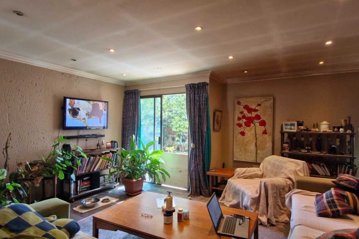 A cozy living room featuring a fireplace, recessed lighting, and a sliding glass door providing access to the outdoor area.