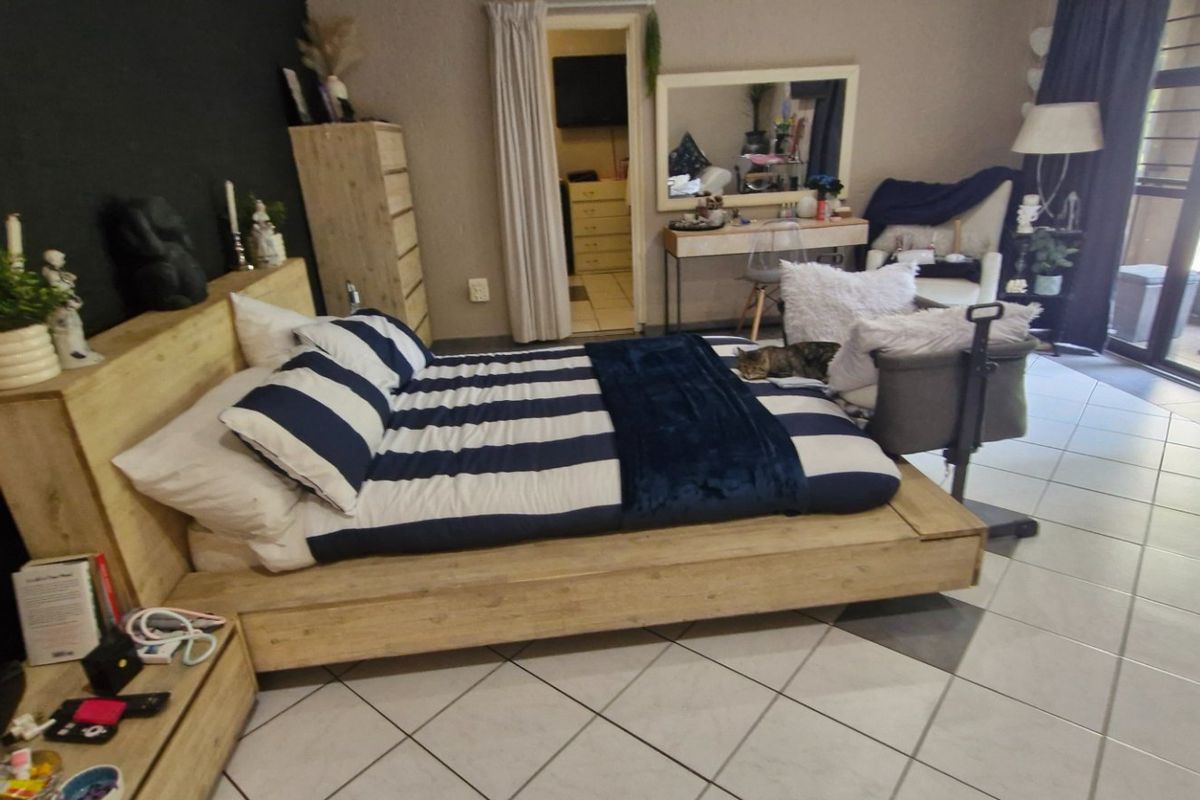 A bedroom featuring tiled flooring and a sliding glass door providing access to an outdoor patio area.
