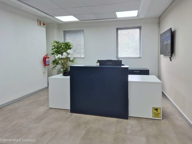 A professional commercial office reception area featuring a built-in reception desk, drop ceiling with recessed lighting, and neutral flooring.