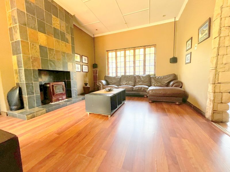 Spacious living room featuring a prominent tiled fireplace with a built-in wood-burning stove and warm-toned hardwood flooring.