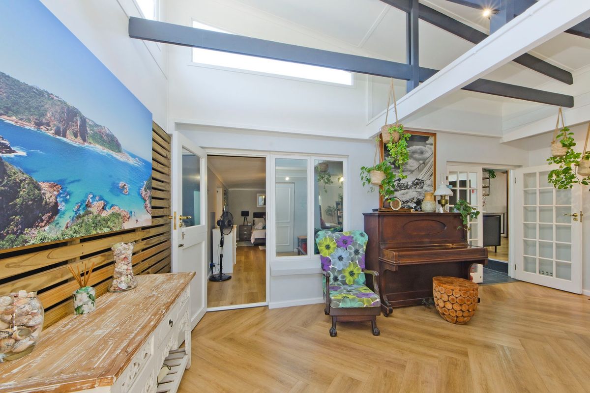 Spacious living area featuring high vaulted ceilings with exposed beams, herringbone timber flooring, and abundant natural light through clerestory windows.