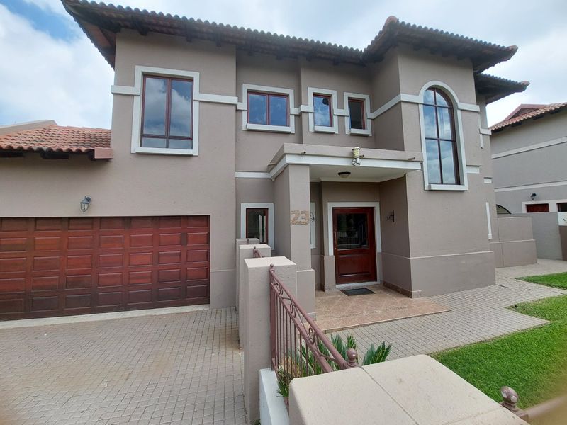 Front elevation of a double-story house featuring a paved driveway, double garage, and a covered entrance with a timber door.