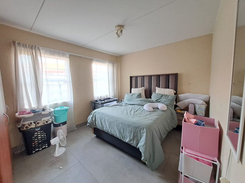 A bedroom featuring tiled flooring and neutral wall finishes, offering a functional space ready for cosmetic updates and personalization.