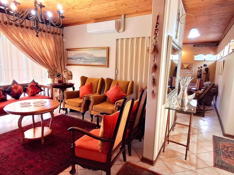 A cozy living room featuring a timber-clad ceiling, tiled flooring, and a split-system air conditioner, providing a warm and inviting atmosphere.