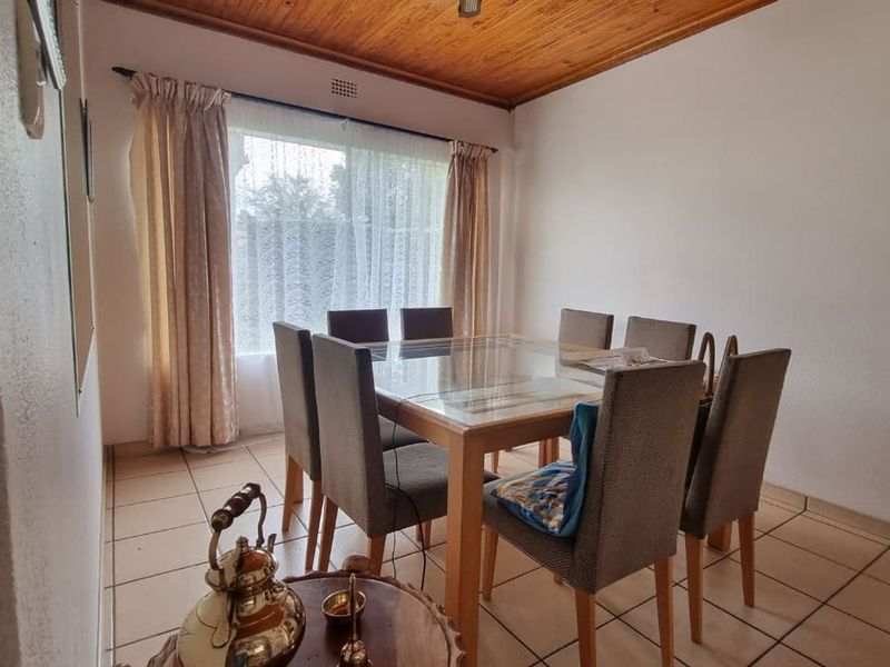 A dining room featuring tiled flooring and a timber-paneled ceiling, providing a functional space for family meals.