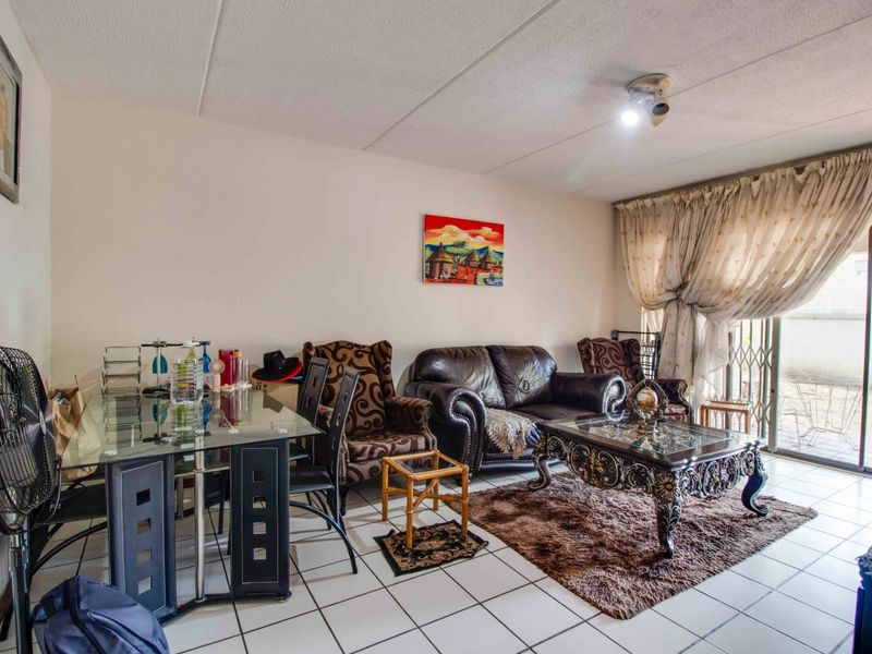 Open-plan living and dining area featuring tiled flooring and a sliding glass door providing access to the outdoor space.