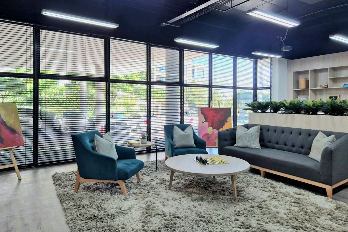 Modern commercial office space featuring large floor-to-ceiling windows, exposed black industrial-style ceiling, and built-in shelving units.