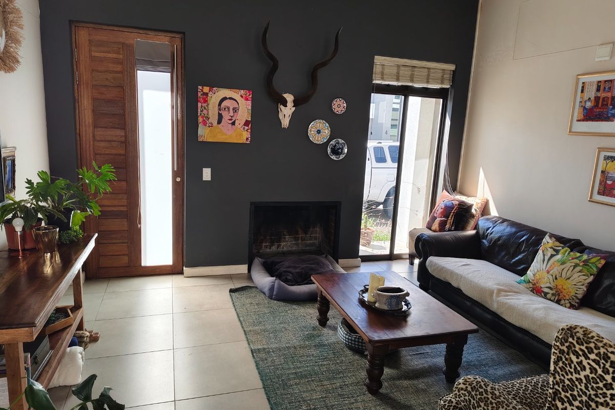 A cozy living room featuring a built-in fireplace, tiled flooring, and direct access to the exterior through a sliding glass door.