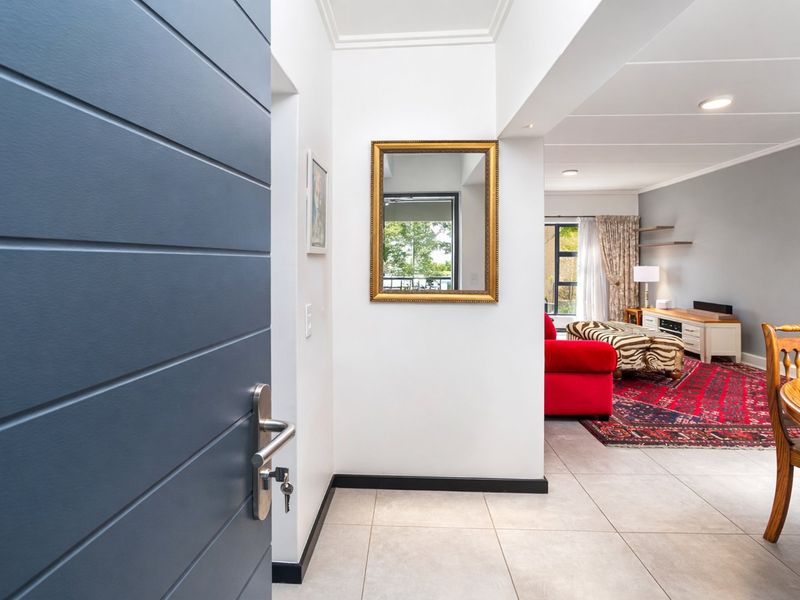 A welcoming entrance hall featuring tiled flooring and clean white walls, leading directly into the open-plan living and dining area.