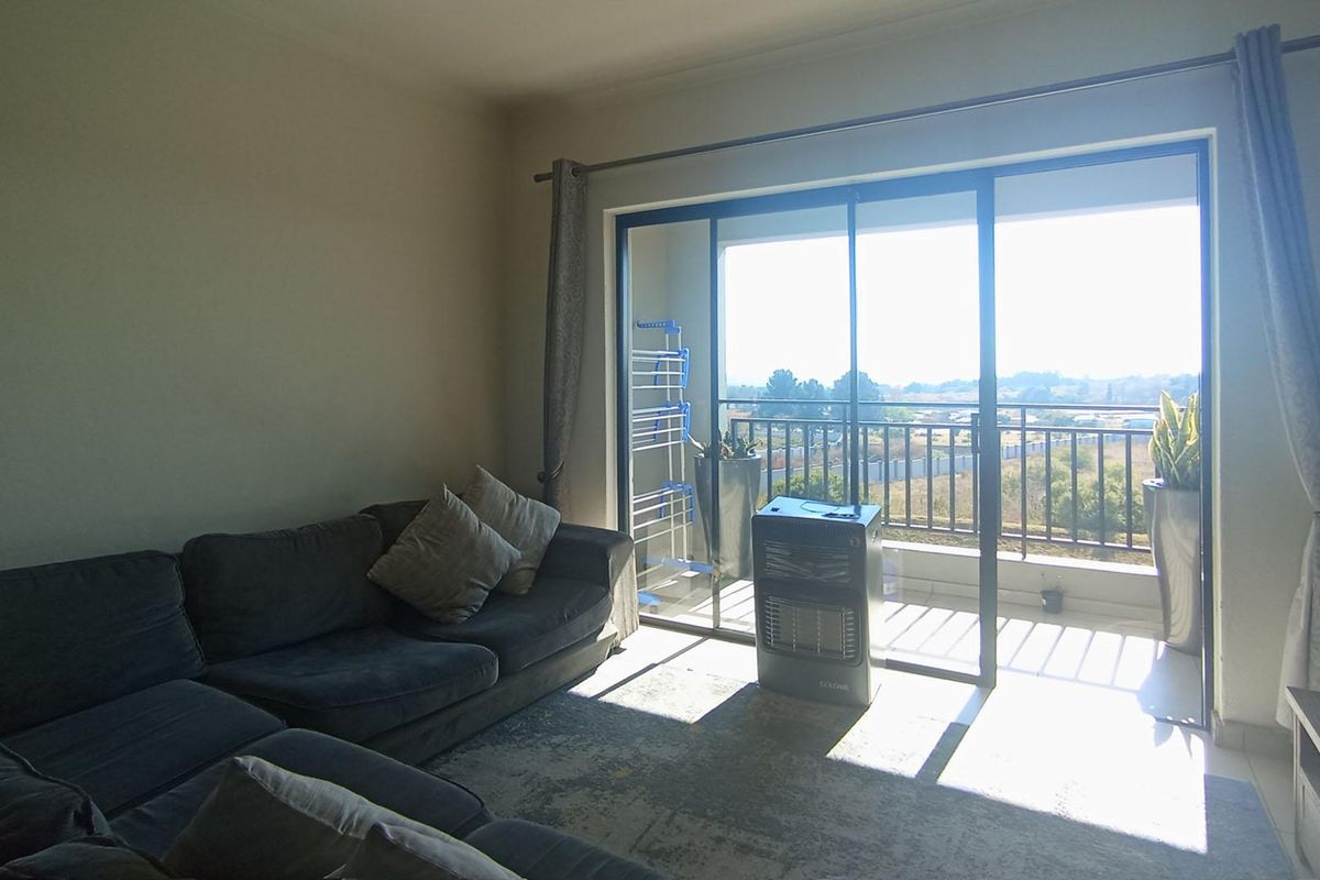 Living room featuring large sliding glass doors that open onto a private balcony with scenic views, providing ample natural light to the space.