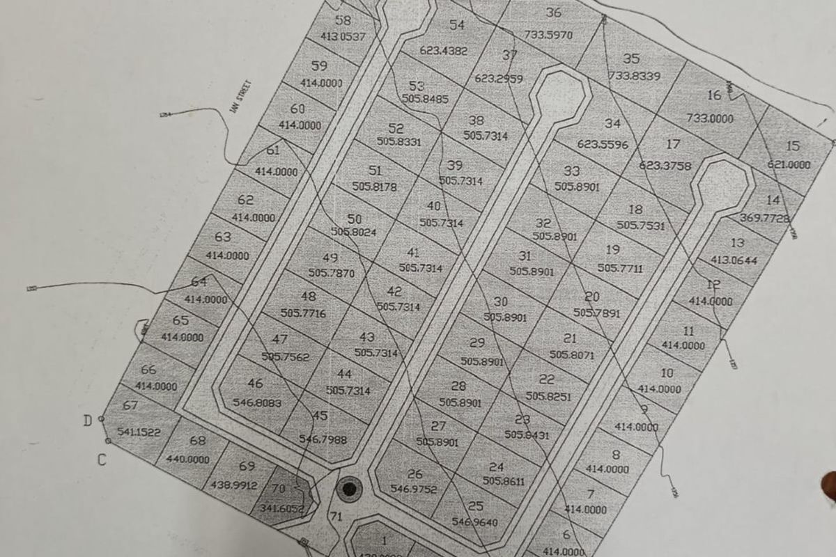 A detailed site layout plan showing multiple residential land plots with individual numbering and area measurements.