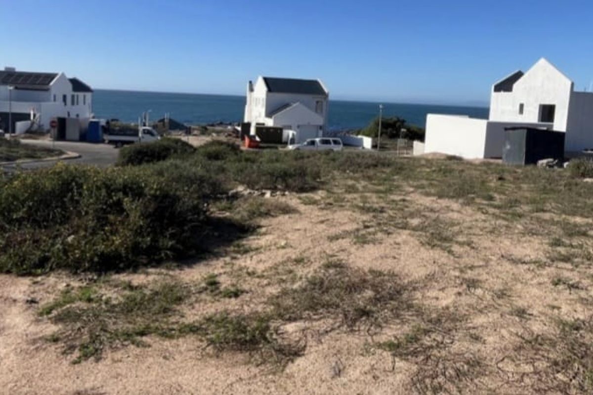 A vacant residential plot situated in a coastal neighborhood, offering potential for development with surrounding established homes and ocean views.