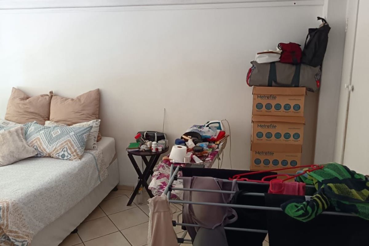 A bedroom featuring tiled flooring and a built-in cupboard, providing a functional space for rest and storage.