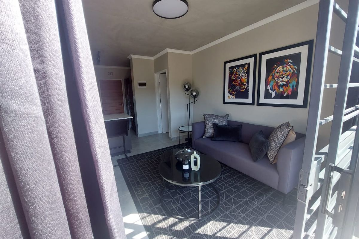 A well-maintained living room featuring neutral wall tones, tiled flooring, and a modern flush mount ceiling light, creating a comfortable and inviting atmosphere.