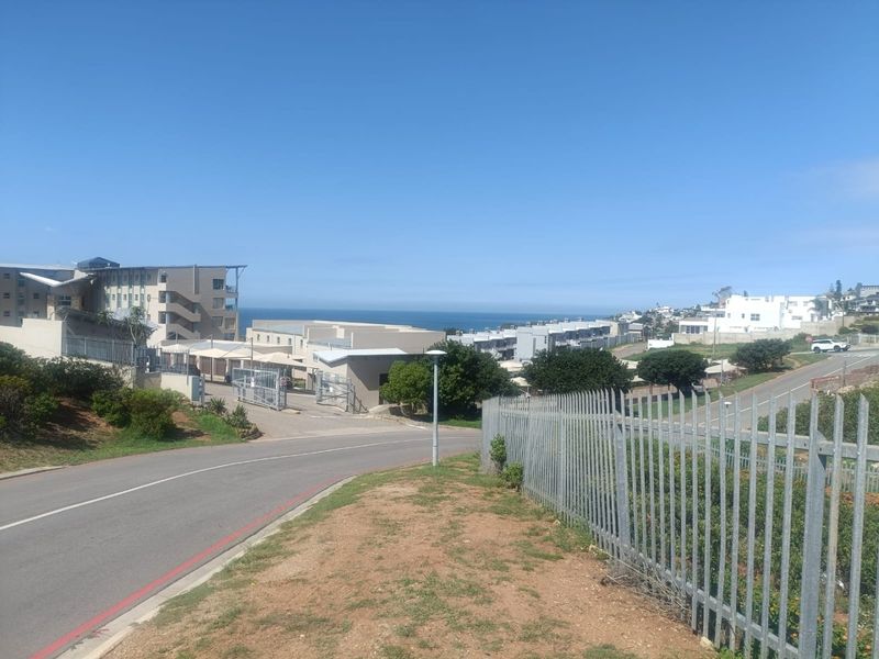A street-level view of the residential area showing paved roads, security fencing, and surrounding coastal neighborhood infrastructure.
