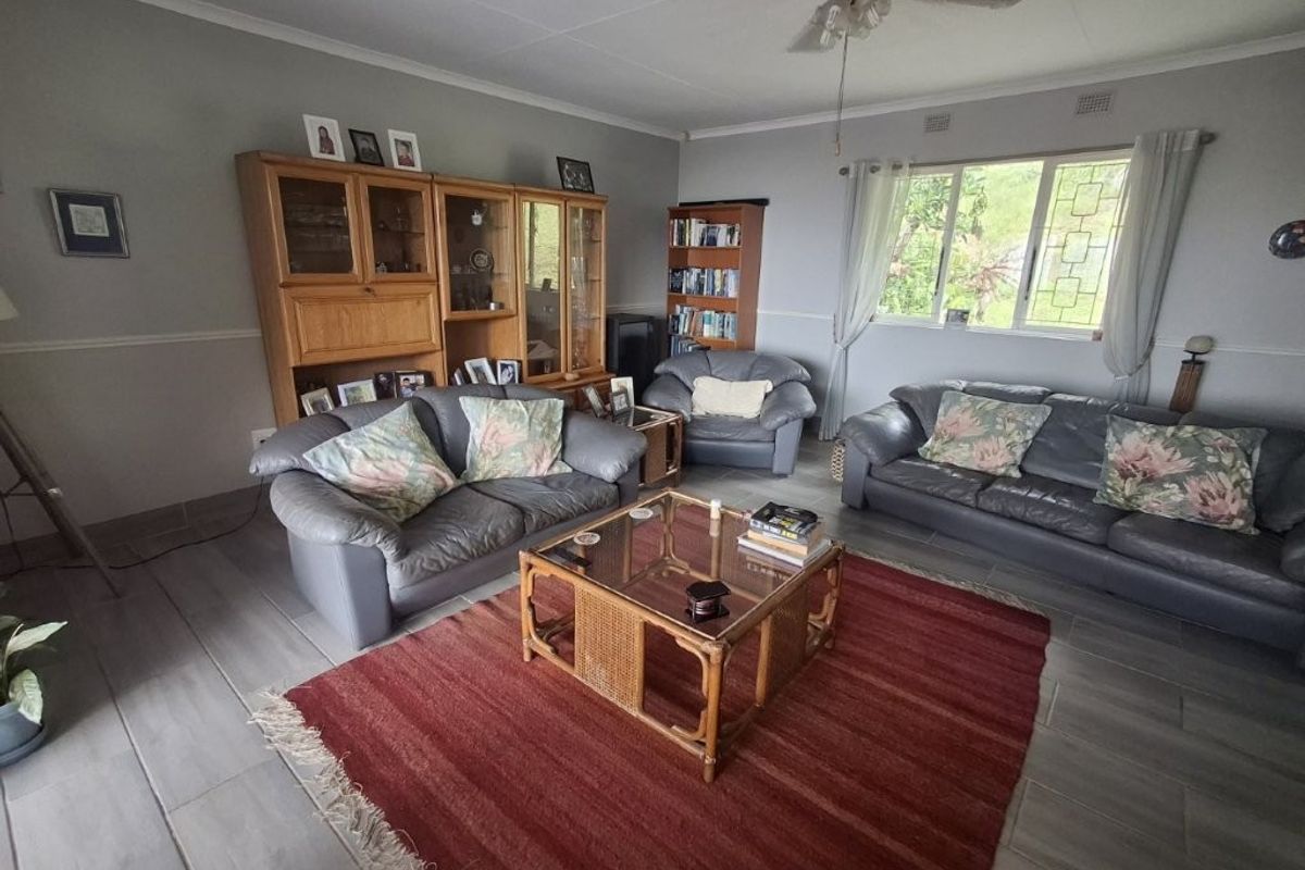 A spacious living room featuring neutral wall tones, tiled flooring, and a ceiling fan, offering a comfortable and functional living space.