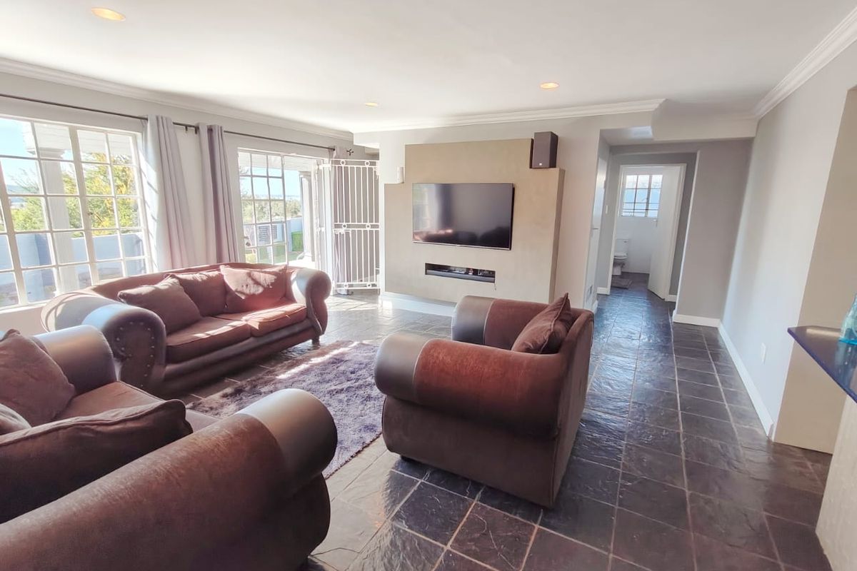 Spacious living room featuring slate tile flooring, a built-in fireplace, recessed lighting, and direct access to the outdoor area through french doors.