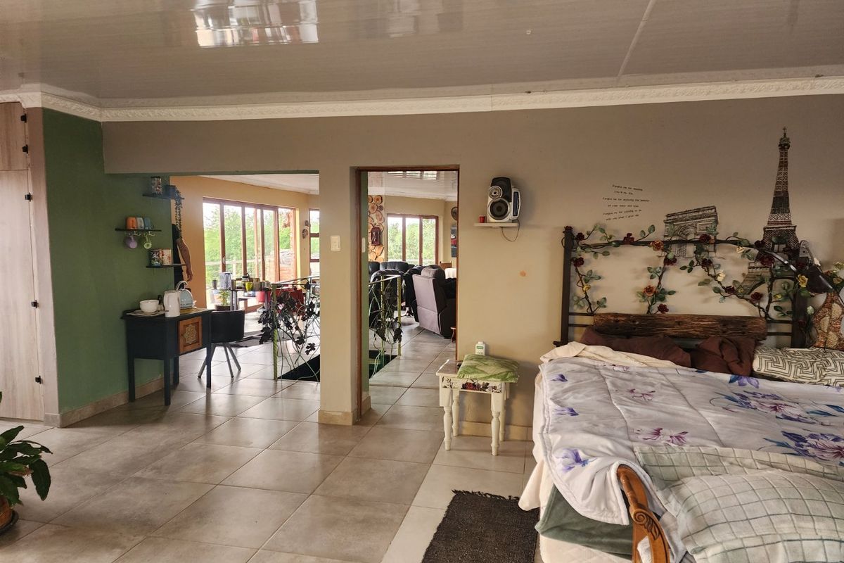 Spacious bedroom featuring tiled flooring, built-in cabinetry, and a glossy ceiling, with an open layout connecting to adjacent living areas.