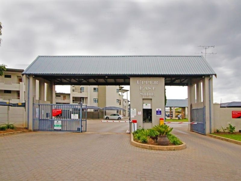 Main entrance gate and security checkpoint for the Upper East Side apartment complex, featuring controlled access, boom gates, and perimeter electric fencing.