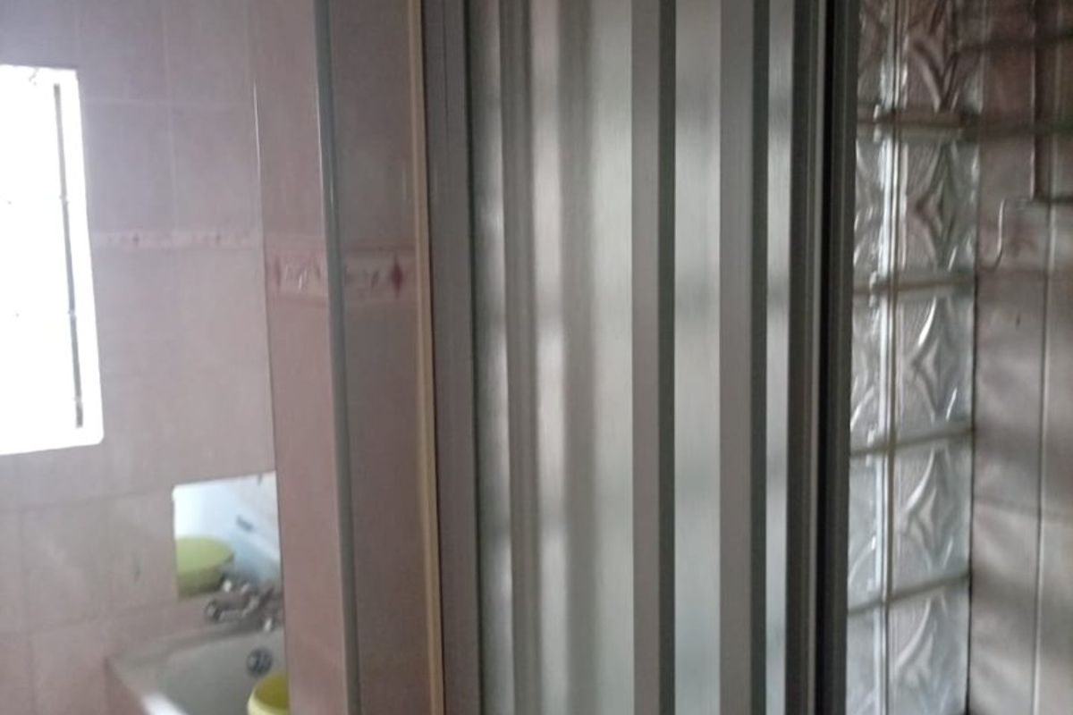 A dated bathroom featuring a bathtub, shower enclosure, and decorative glass block wall elements.