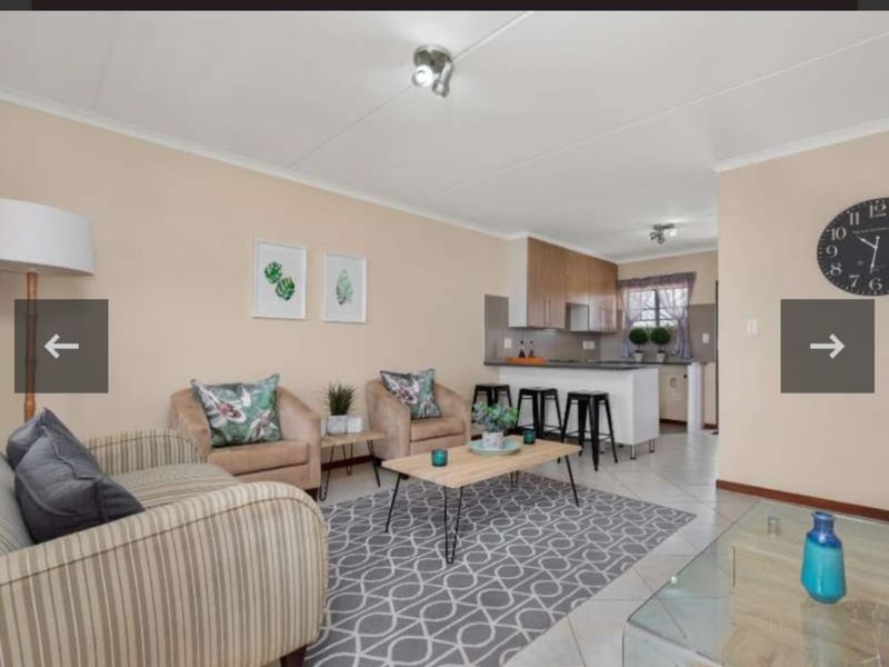 Open plan living area featuring tiled floors and a functional kitchen with built-in cabinetry, oven, and hob, creating a cohesive and practical living space.