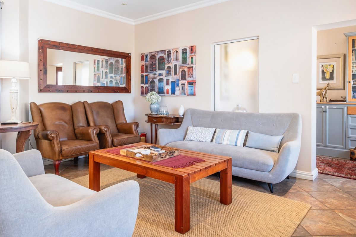A well-maintained living room featuring tiled flooring, cove cornicing, and built-in cabinetry, offering a comfortable and inviting space.