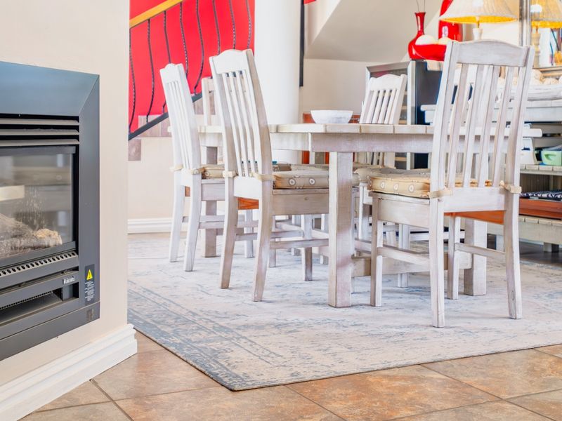 A dining area featuring tiled flooring and a modern built-in gas fireplace, creating a warm and functional space for meals.