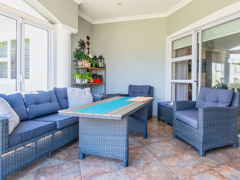 A covered patio area featuring tiled flooring and large sliding glass doors that provide seamless access to the interior living space.