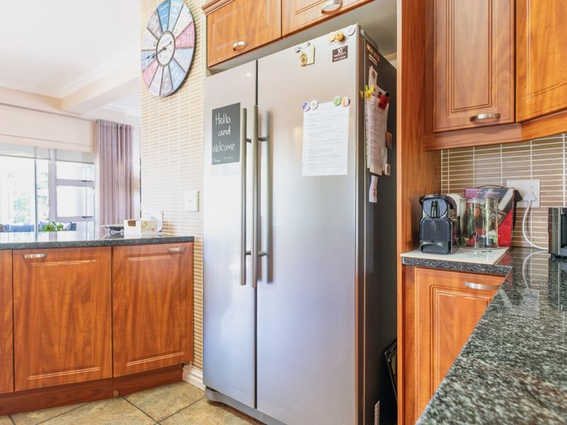 A functional kitchen featuring warm-toned wooden cabinetry, granite countertops, and a tiled backsplash, offering a classic and practical workspace.