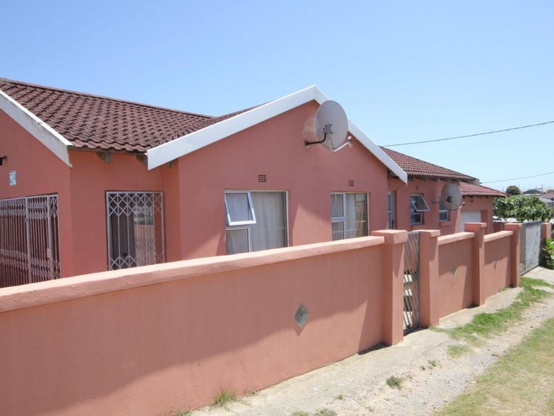 A single-story residential house featuring a tiled roof, perimeter boundary wall, and security gates over windows.
