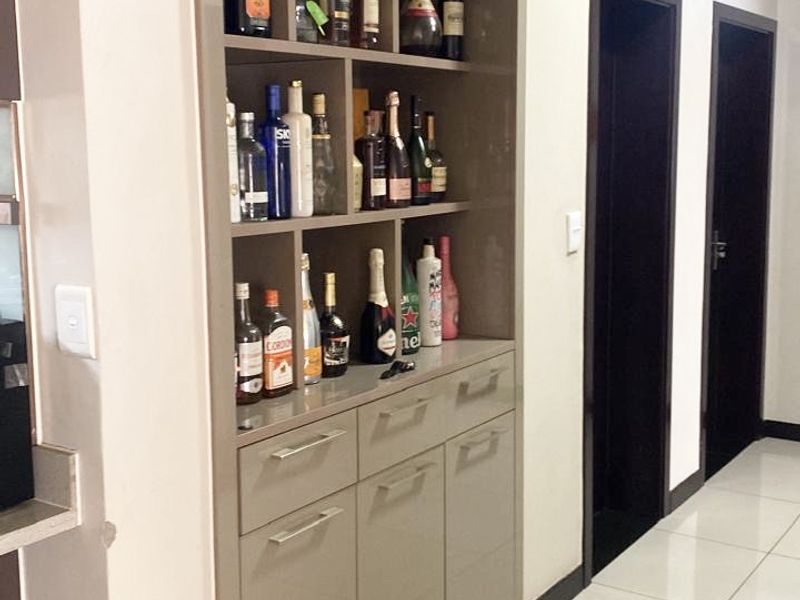 A well-maintained hallway featuring modern built-in cabinetry with integrated shelving and sleek tiled flooring.