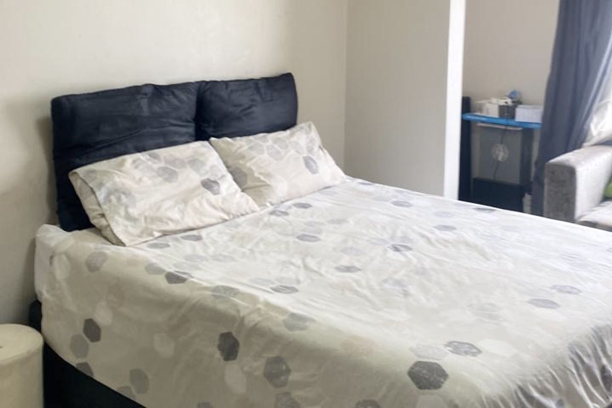 A bedroom featuring tiled flooring and crown molding, providing a neutral foundation for personal styling.