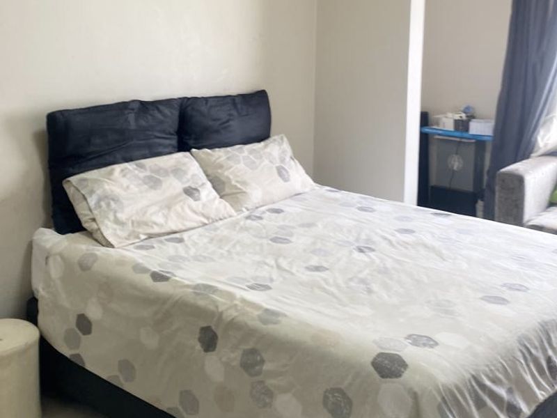 A bedroom featuring tiled flooring and crown molding, providing a neutral foundation for personal styling.