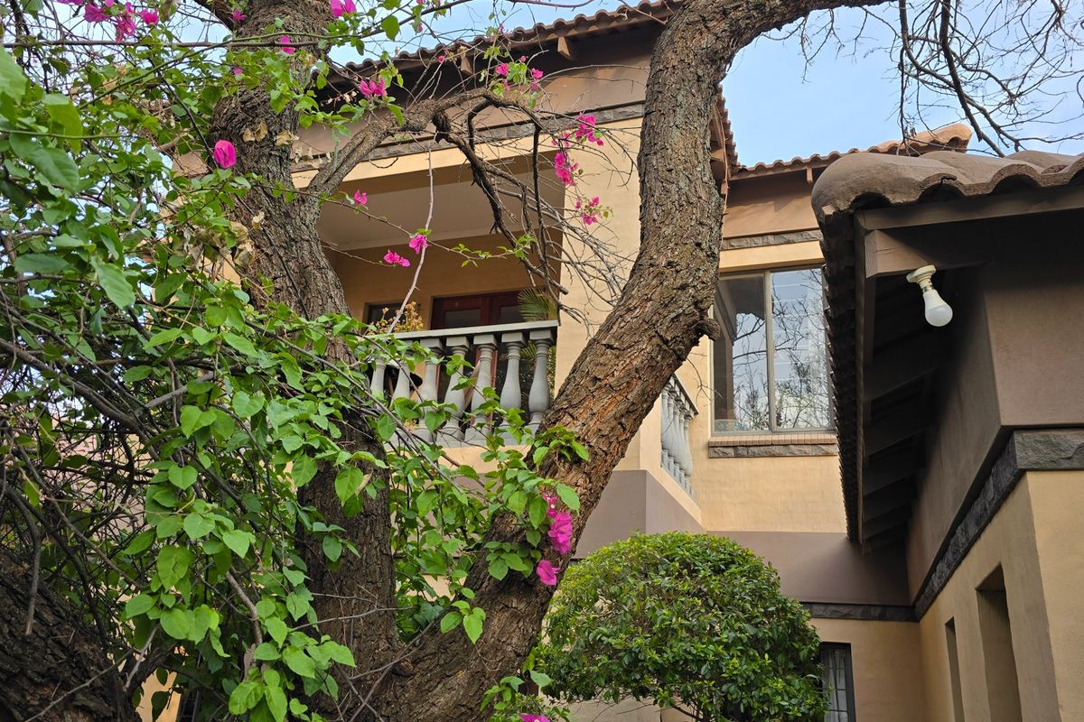 A view of the rear exterior facade featuring a balcony with a decorative balustrade and tiled roofing.