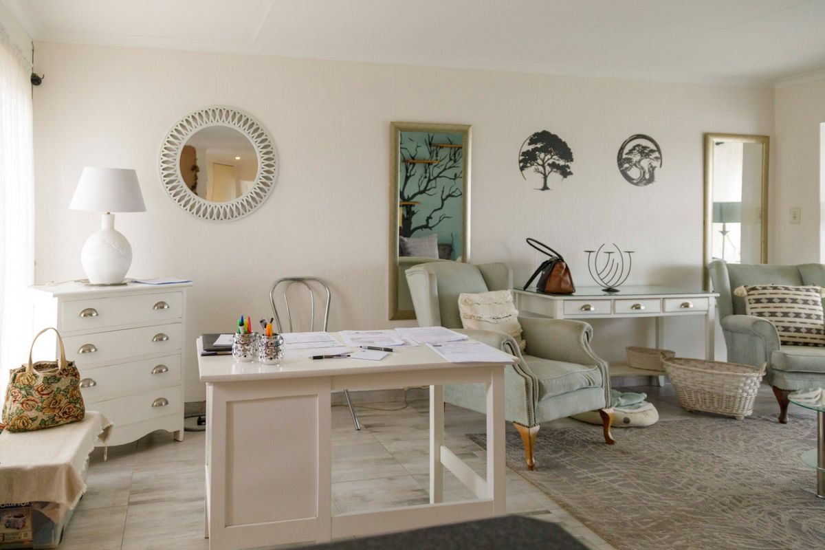 A bright and well-maintained living area featuring neutral wall tones, tiled flooring, and coved ceiling details, providing a versatile space for relaxation or home office use.