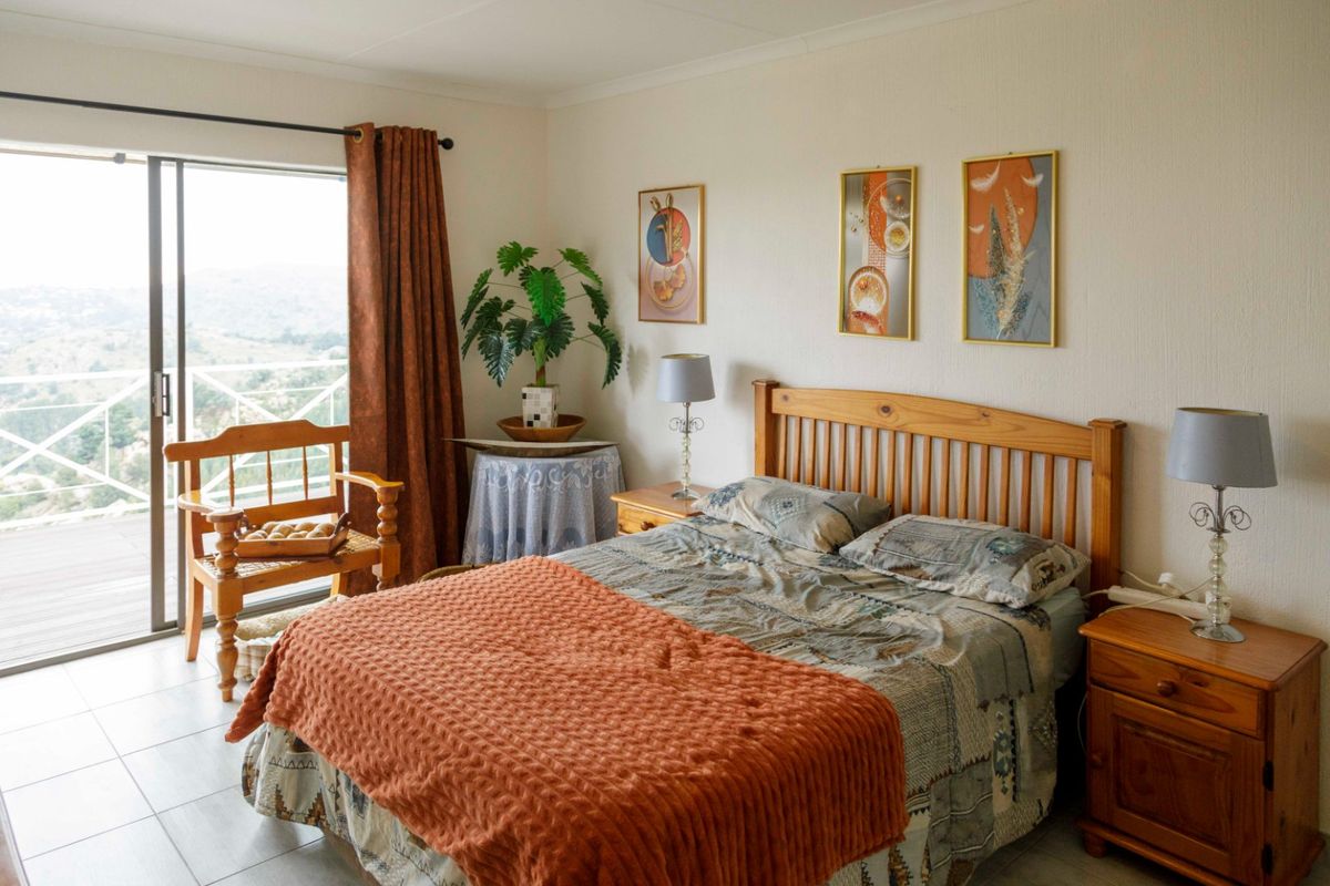 A bedroom featuring tiled flooring and a sliding glass door that opens onto a balcony with scenic views.
