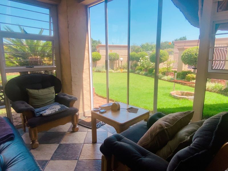Enclosed patio area featuring tiled flooring and large sliding glass doors providing direct access and views to the landscaped garden.