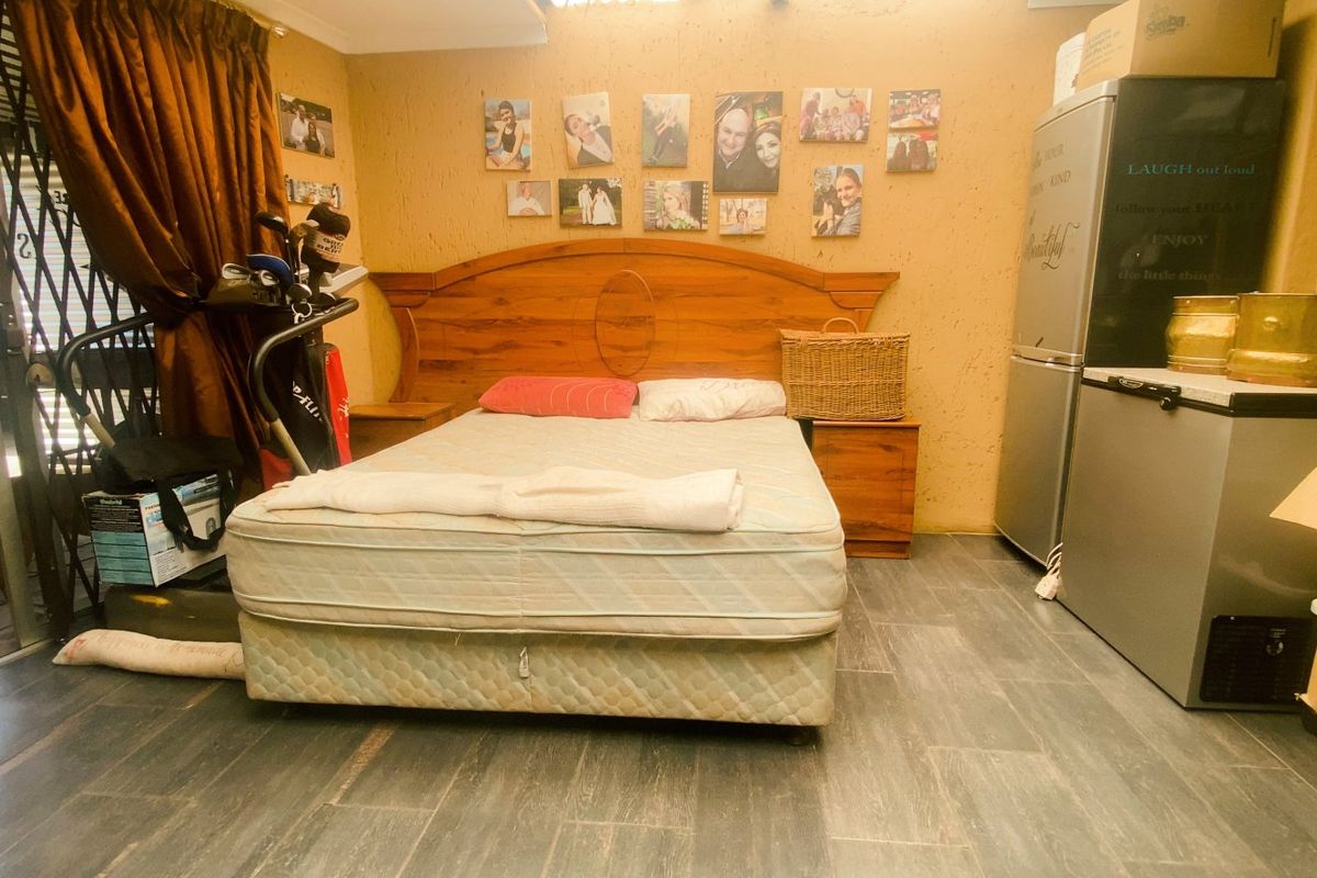 A bedroom featuring tiled flooring and direct access to an outdoor patio area through a sliding security door.