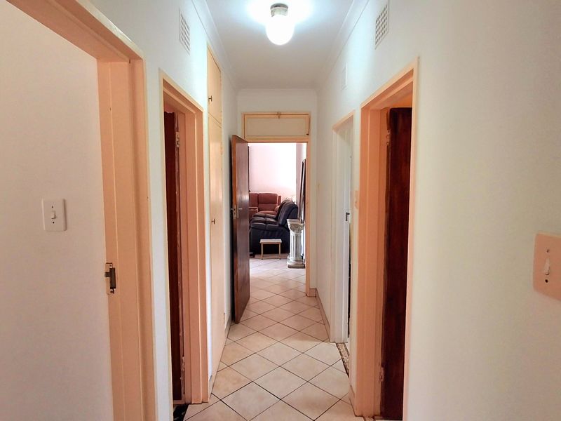 A functional hallway featuring tiled flooring, built-in storage, and access to multiple rooms, providing a central circulation space within the home.