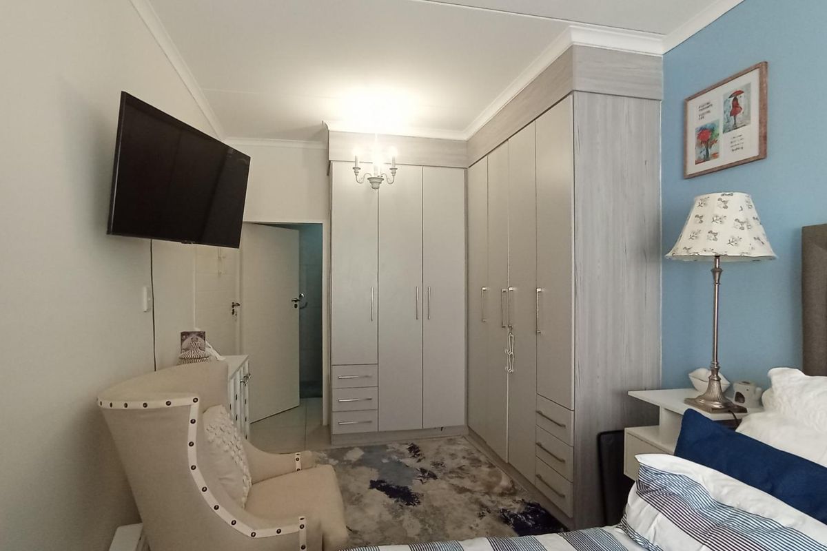 A well-maintained bedroom featuring extensive built-in cabinetry with integrated storage and neutral finishes.